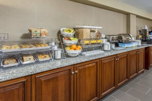 Un espace buffet proposant divers plats et une station où l'on peut se servir du café.