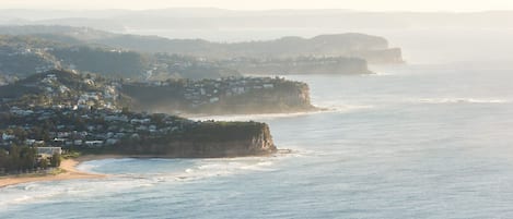 A coastal town with houses on a hillside overlooking the sea.