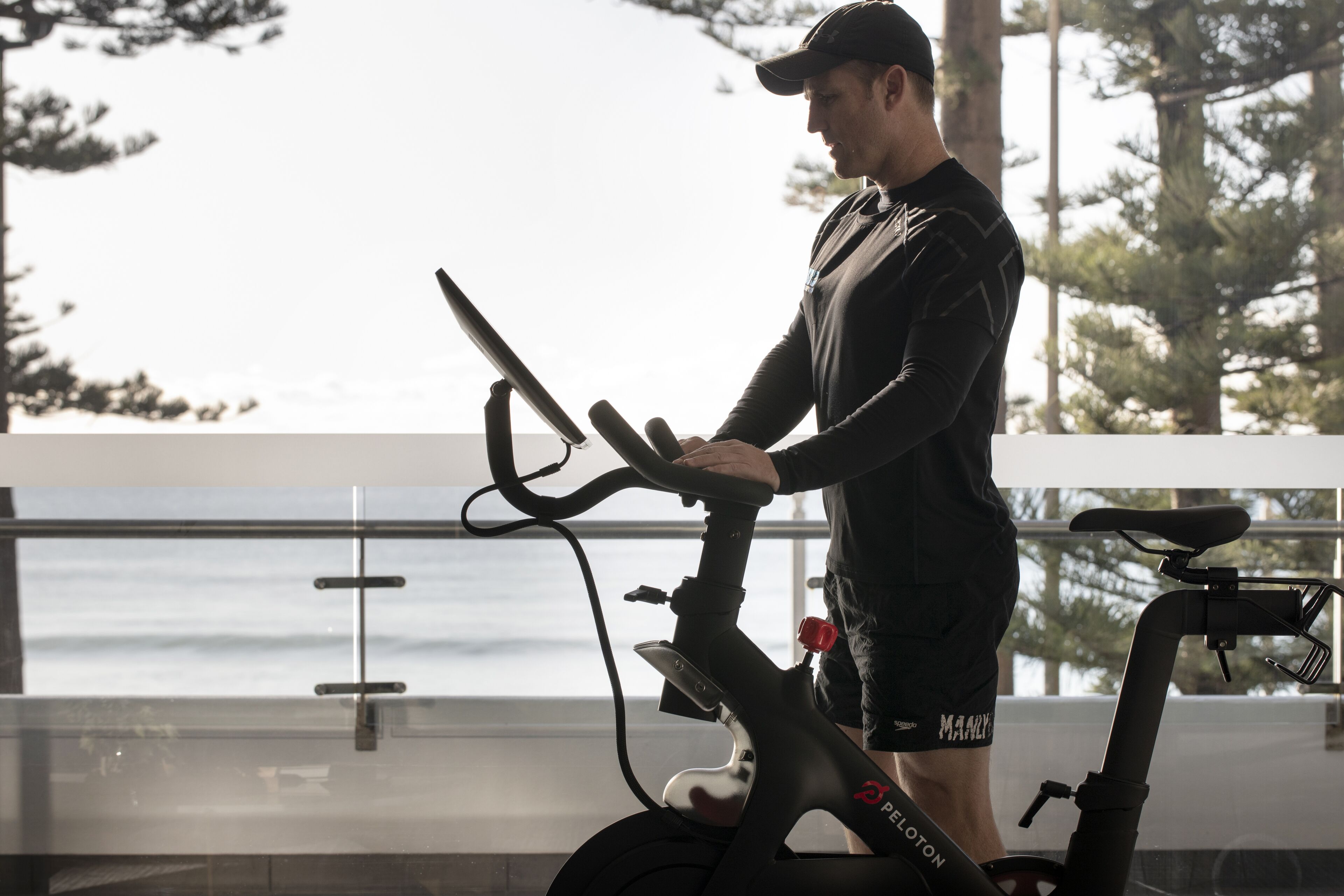 A person using an exercise bike with a view of the ocean.