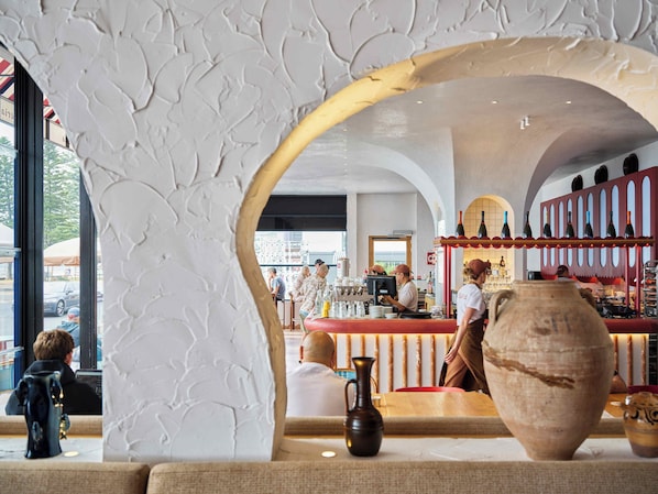 Un intérieur comprenant un espace bar, des sièges et un grand vase.