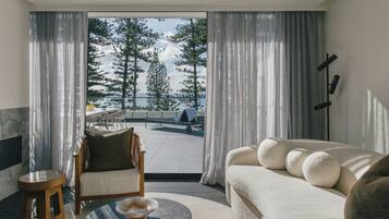 Una sala moderna con un sofá, un sillón, una mesita y vistas a un paisaje nevado a través de amplios ventanales.