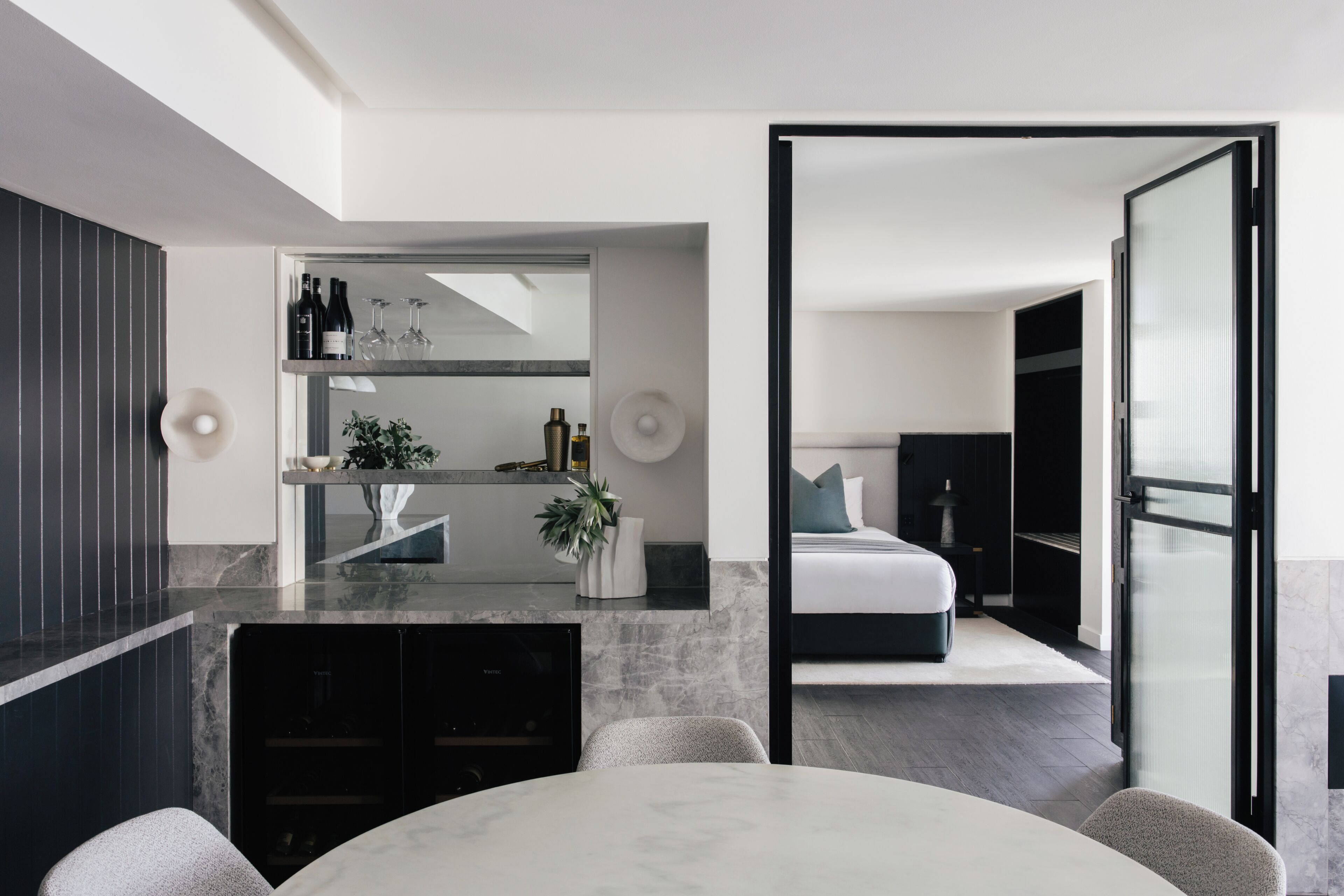 A modern bedroom with a bed, a nightstand, and a dresser.