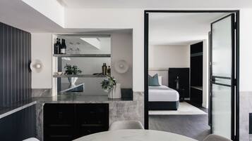 A modern bedroom with a bed, a nightstand, and a dresser.