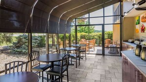 Un restaurant au décor moderne, avec des luminaires au plafond aux formes arrondies, de grandes fenêtres et une terrasse.