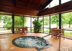 A hot tub area with a wooden ceiling and large windows.