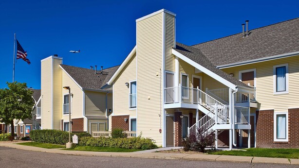 A two-story building with a central staircase and a flagpole with an American flag.