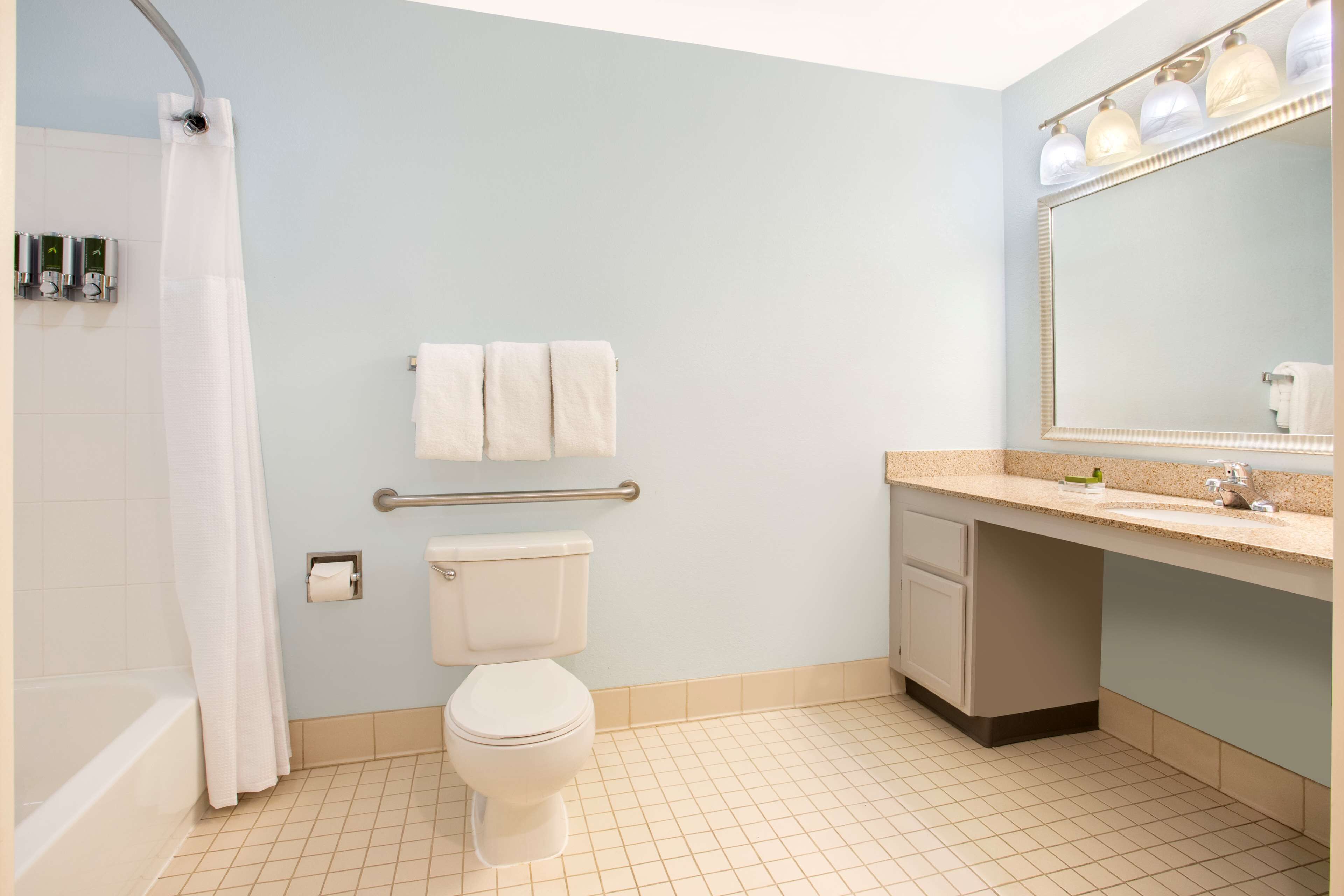 A bathroom with a bathtub, toilet, and sink.