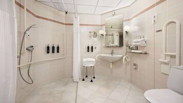 A modern bathroom with a shower, sink, and toilet.