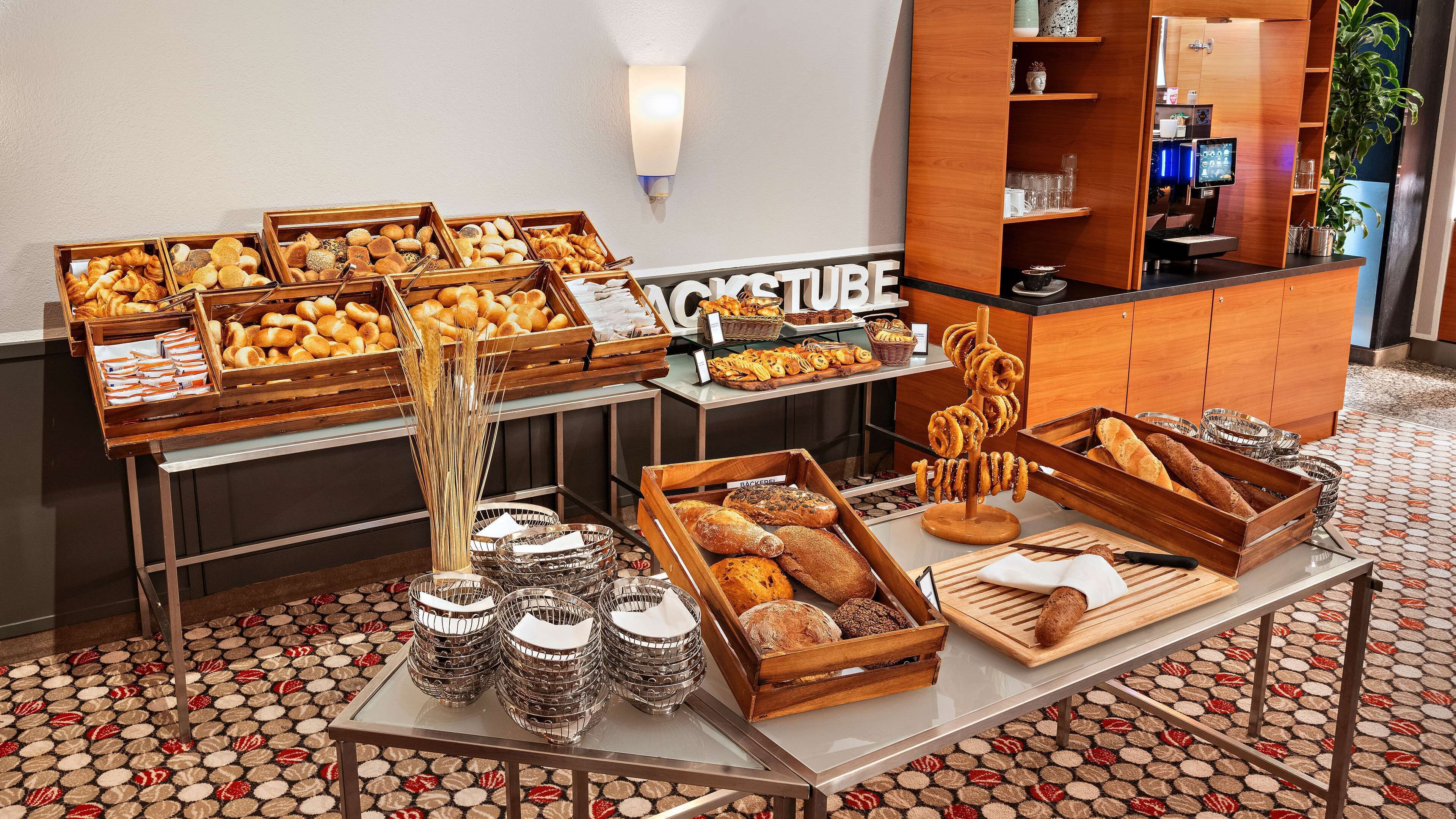 Ein reichhaltiges Buffet mit verschiedenen Brotsorten, Gebäck und einer Kaffeestation.