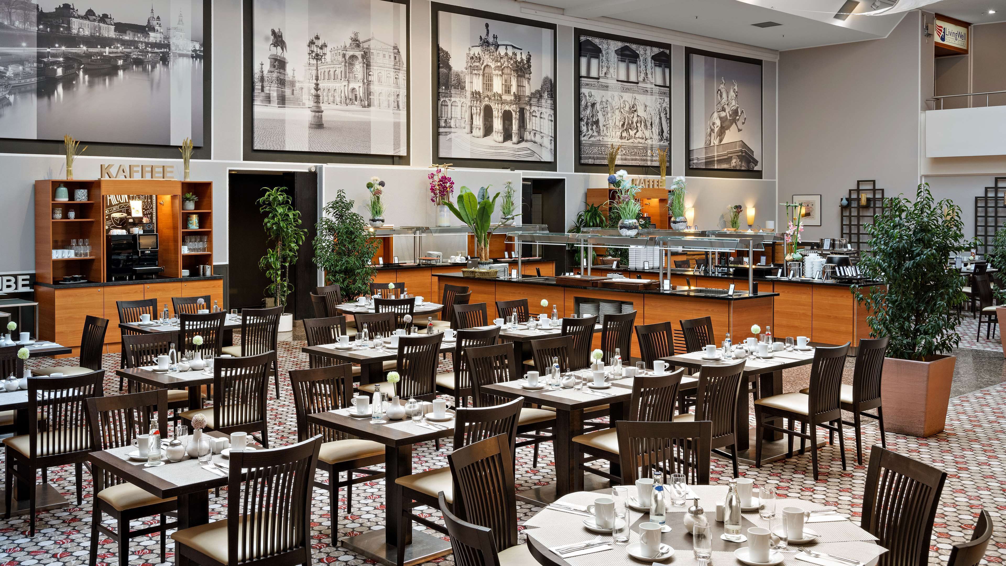 A restaurant with multiple dining tables and chairs, a coffee station, and a bar area.