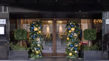 Een hotelentree met een glazen deur, een kerstboom en een bord met Radisson erop.