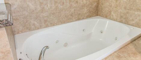 Un baño moderno con una bañera independiente, un tocador con espejo y una zona de ducha.