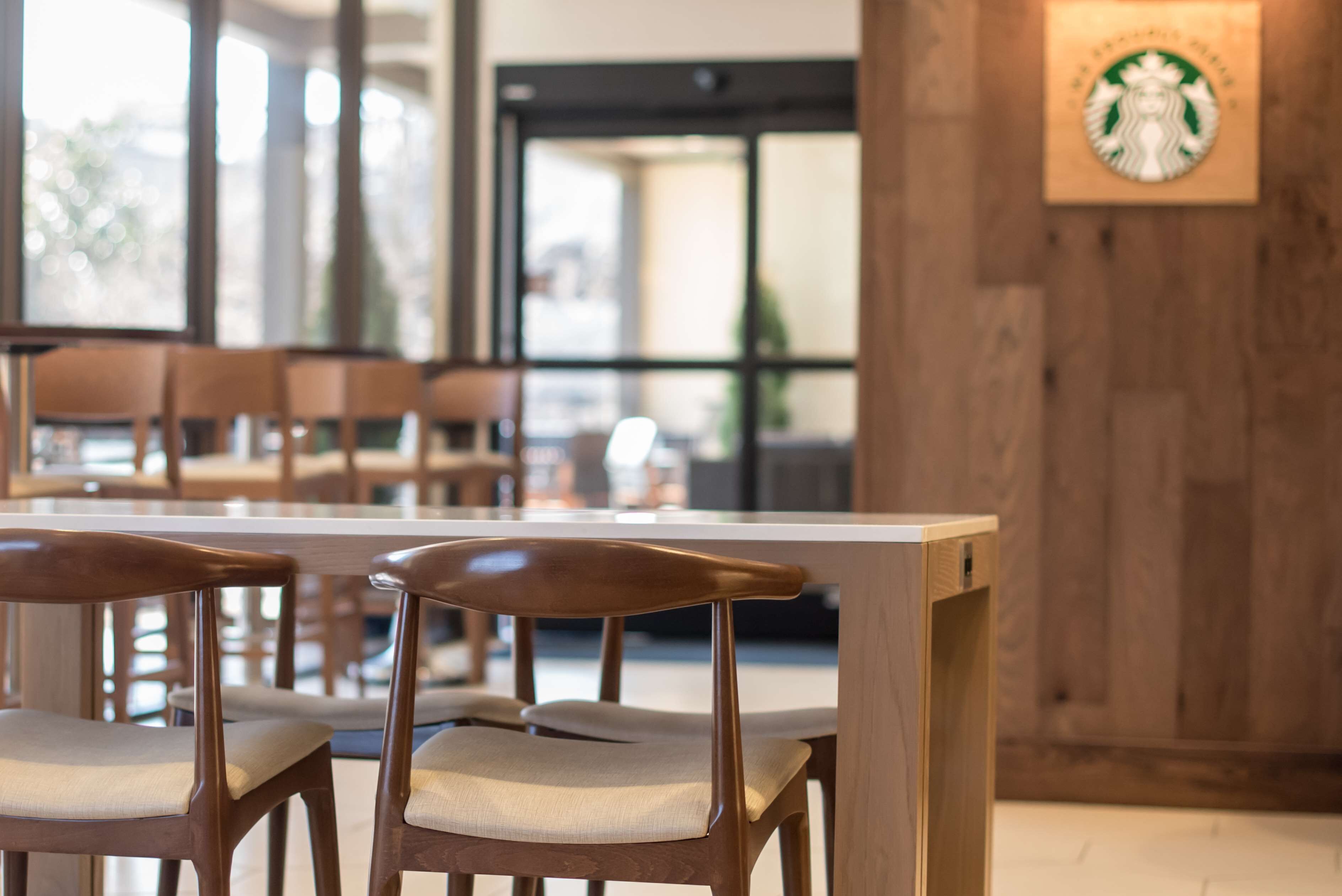 Un espace détente avec des chaises en bois et une table blanche.
