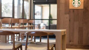 Un espace détente avec des chaises en bois et une table blanche.