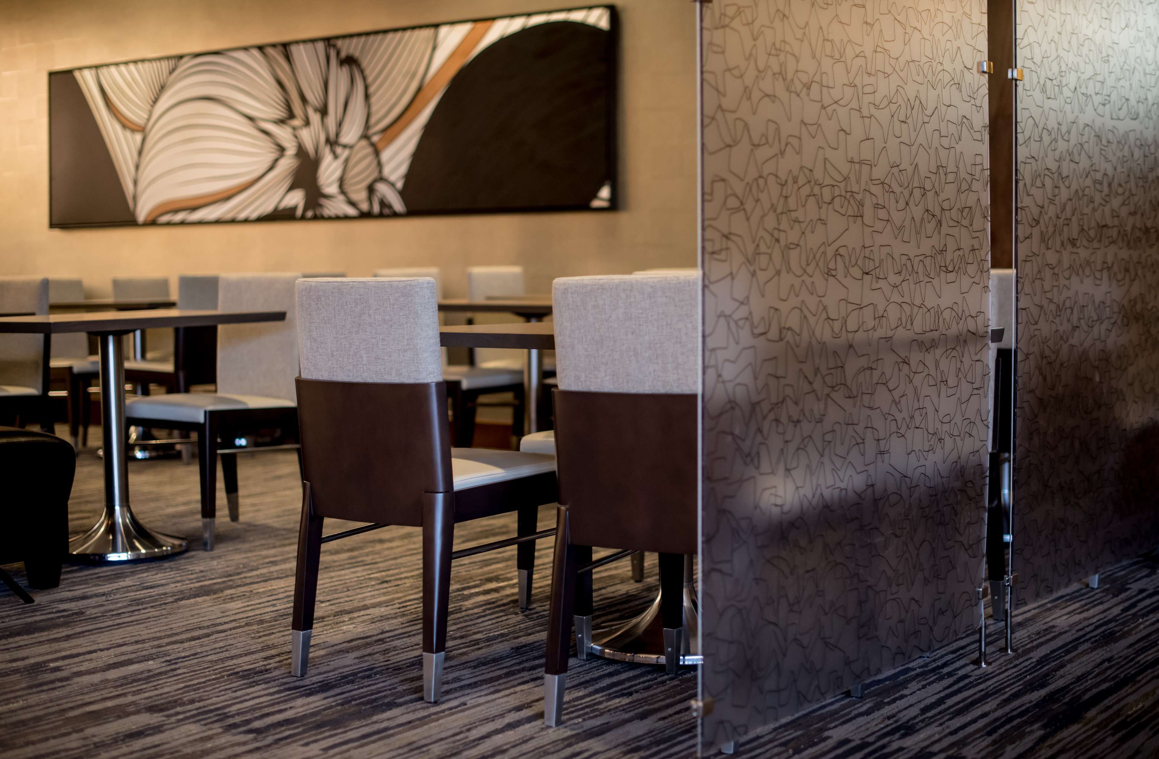A conference room with a large abstract painting on the wall, a patterned wall, and a carpeted floor.
