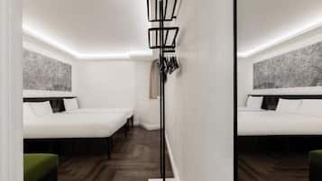 A modern hotel room with two beds, a floor lamp, and a cityscape view.