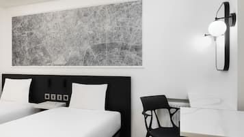 Une chambre d’hôtel moderne avec une grande œuvre d’art abstraite représentant un paysage urbain, une tête de lit noire, deux lits, un bureau avec une chaise et un luminaire fixé au mur.