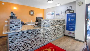 A reception area with a mosaic tile counter, a clock, and a sign about a mobile app. - Econo Lodge Lithonia - Atlanta East (Lithonia)
