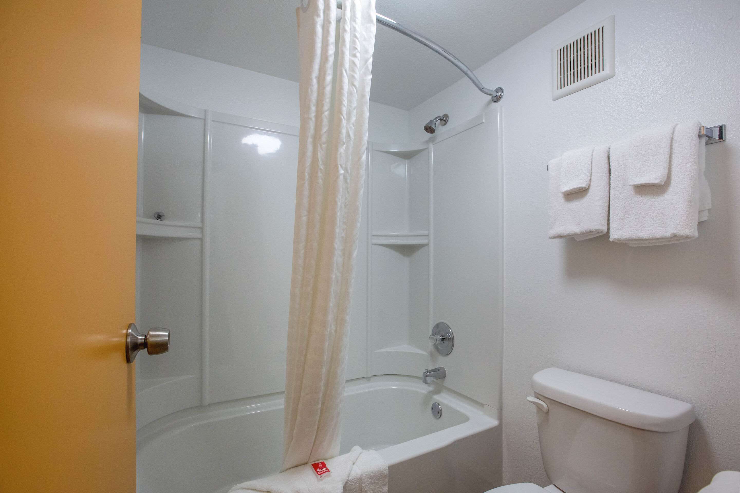 Un baño con bañera, ducha e inodoro.