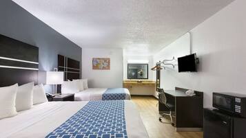 A hotel room with two beds, a desk, a chair, a television, and a microwave.