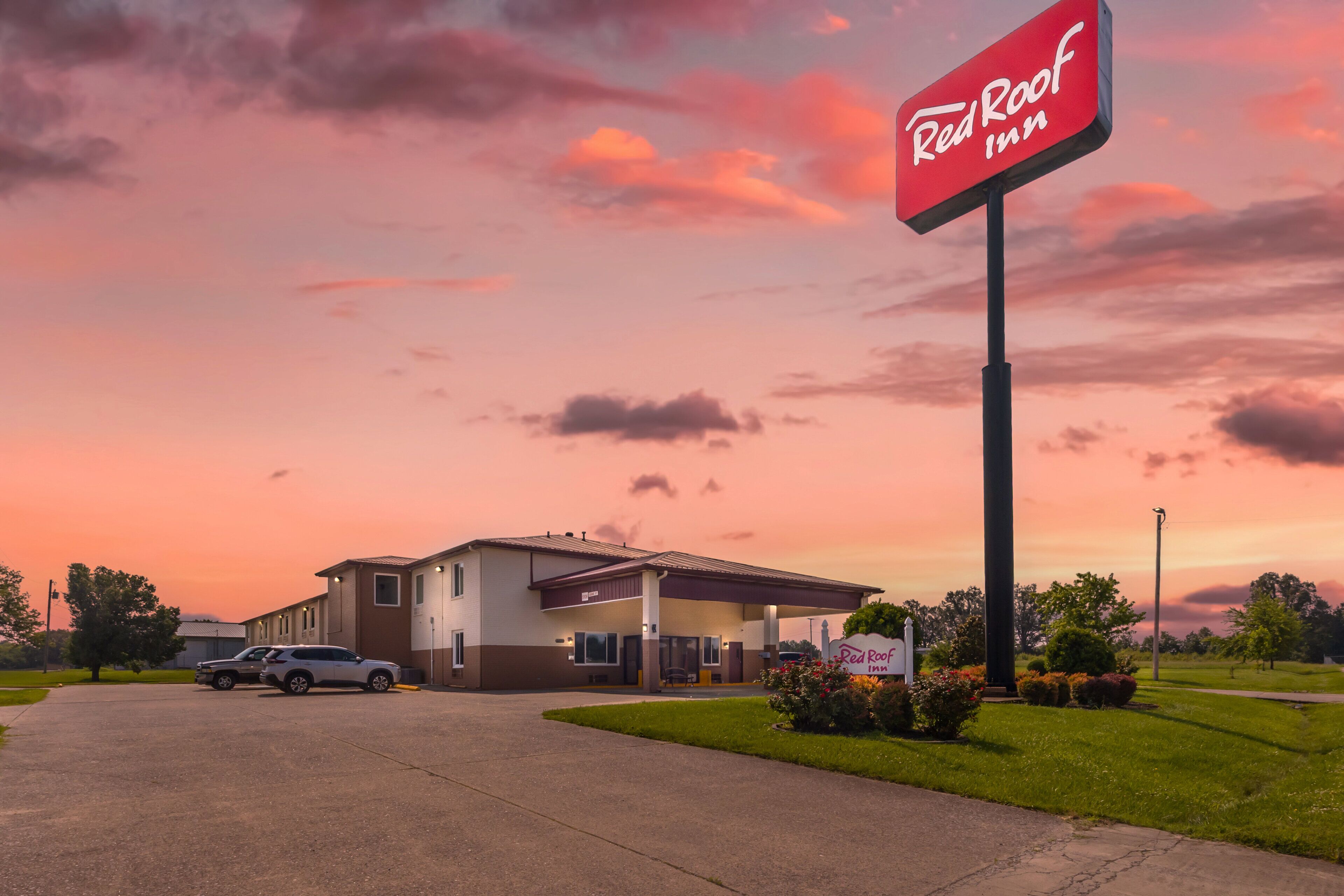 A Red Roof Inn with a clear sky and sunset.