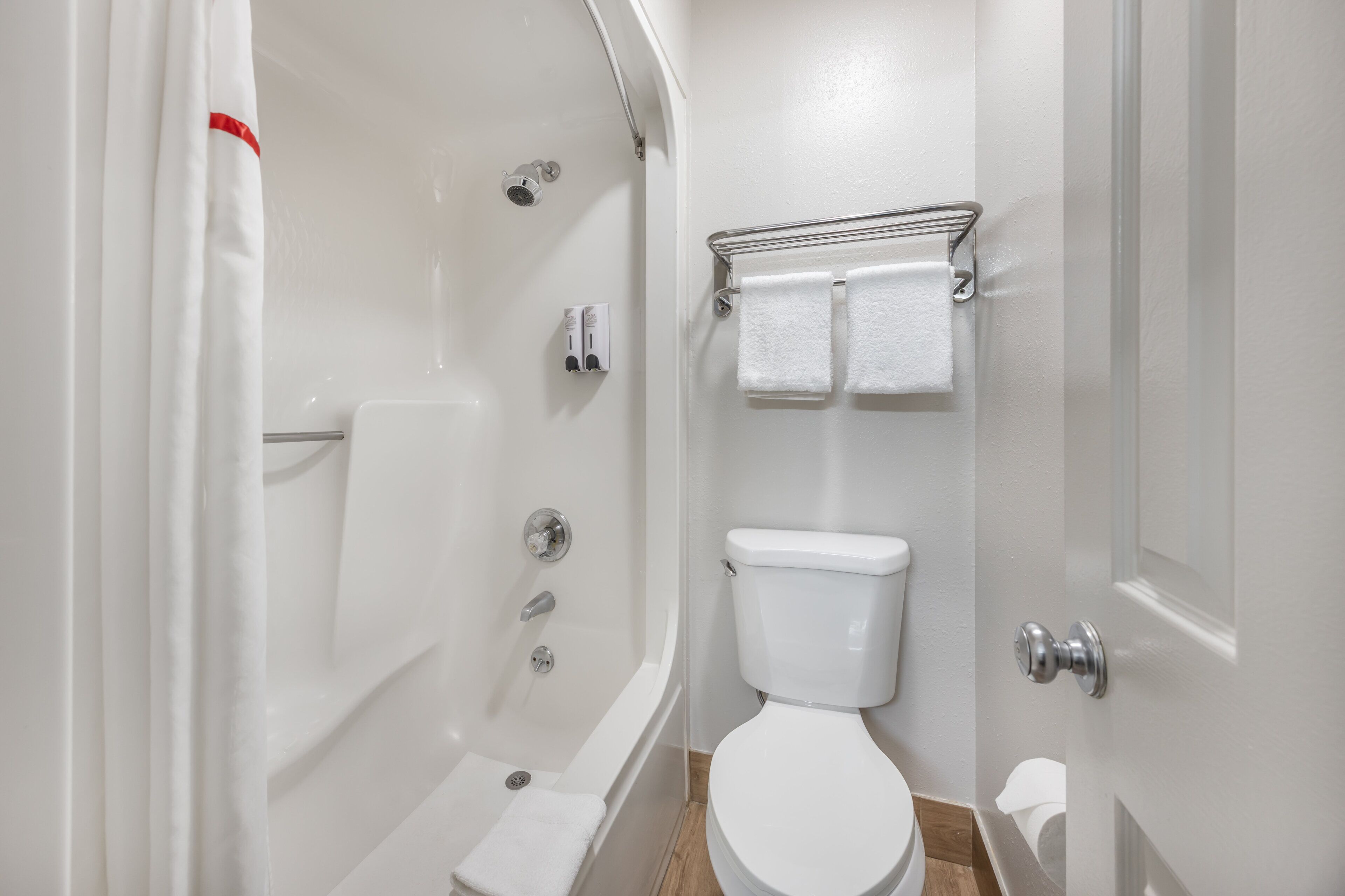 Un baño con bañera, inodoro y perchero.