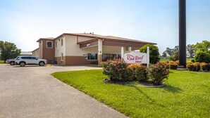 A Red Roof Inn with a two-story building, a parking area, and a well-maintained lawn with flowers. - Red Roof Inn Paducah (Paducah)