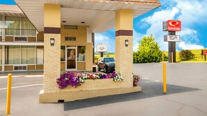 Una estación de servicio con marquesina, un letrero de EconoLodge y un estacionamiento.