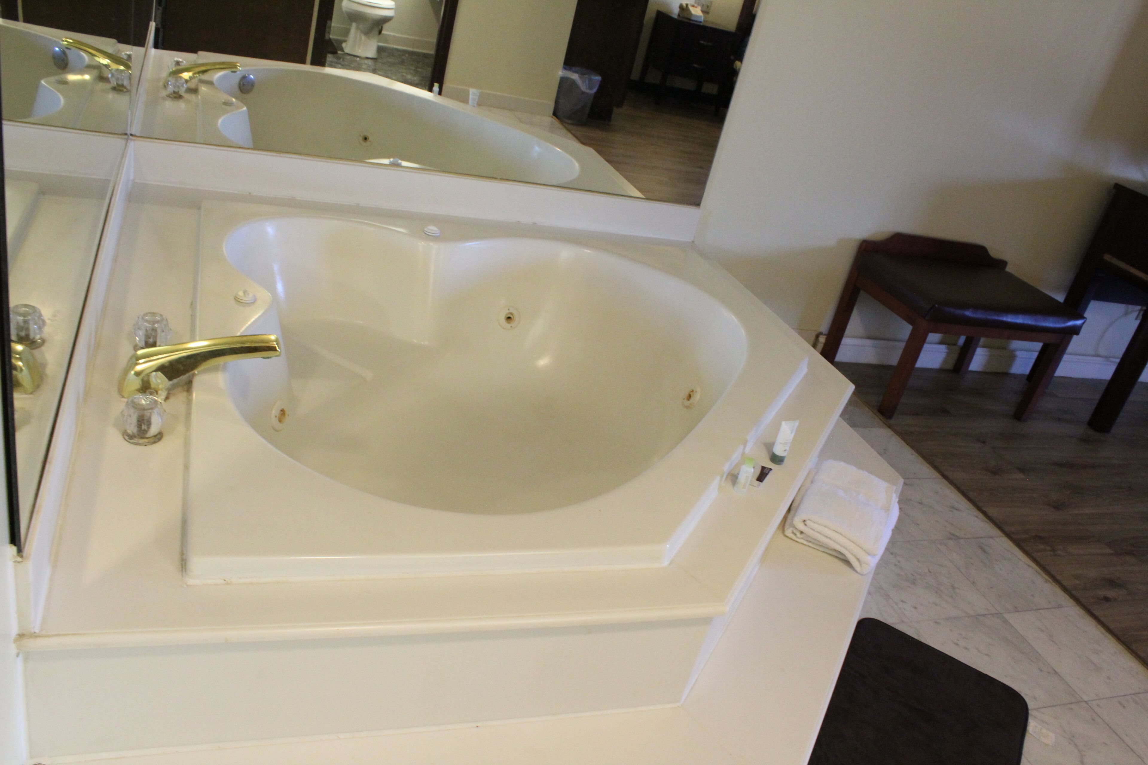 Une salle de bain avec une grande baignoire, un lavabo et un miroir.