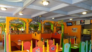 Ein Restaurant mit bunten Sitzgruppen und einer Speisekarte.