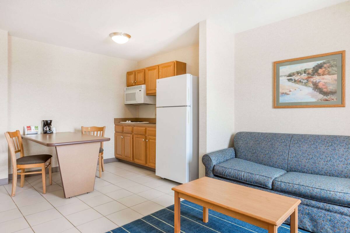 A compact living space with a kitchenette, a dining area, and a sofa.