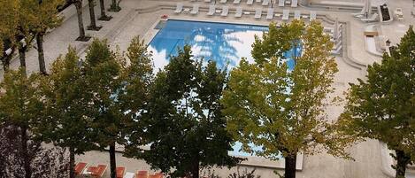 Een binnenzwembad, een buitenzwembad en parasols bij het zwembad