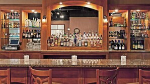 A bar area with wooden chairs, shelves of liquor bottles, and a cash register. - Days Inn by Wyndham Warren (Warren)