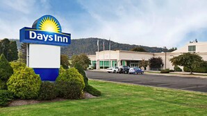 A Days Inn hotel with a clear view of the parking lot and a mountain in the background.