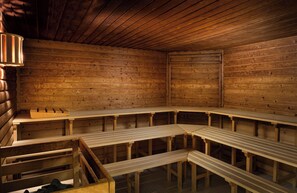 Eine Sauna mit Holzbänken und einer Rückenlehne.