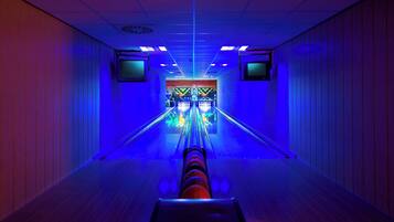 A bowling alley with a neon-lit lane and a colorful bowling ball return system.