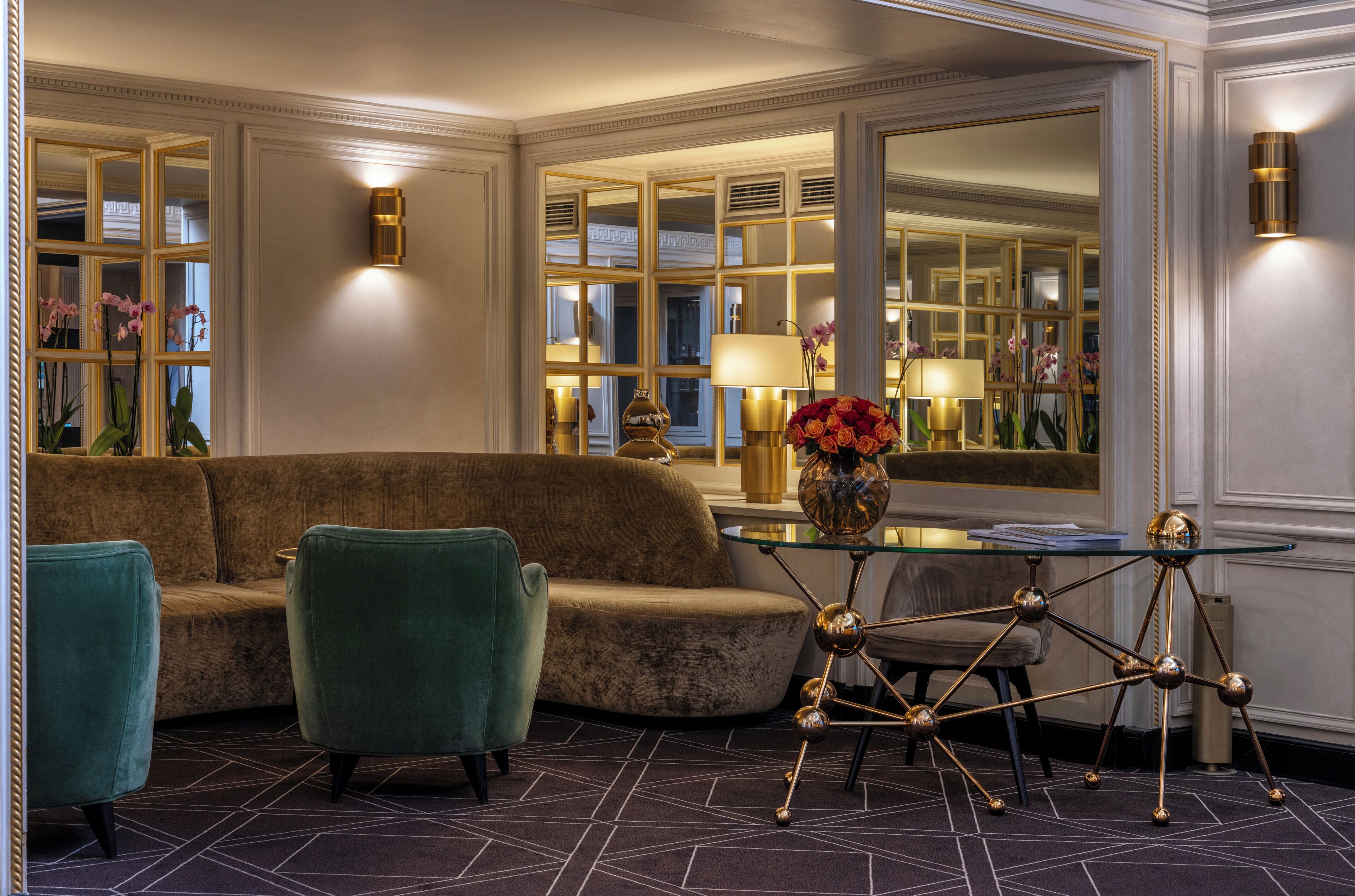 Una habitación con sofá, dos sillones, una mesa de vidrio con un centro decorativo y un espejo que refleja la estancia.