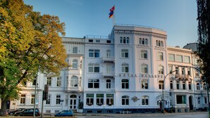 Un edificio histórico con una enseña destacada, ventanas amplias y un balcón.