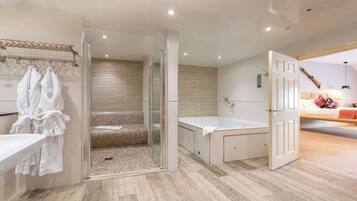A modern bathroom with a glass-enclosed shower, a bathtub, and a walk-in shower.
