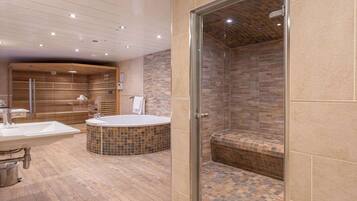 A modern bathroom with a freestanding bathtub, a glass-enclosed shower, and a vanity with a sink and mirror.