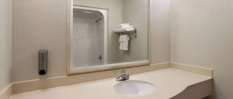 A bathroom with a sink, mirror, and towel rack.