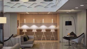 A modern interior with a seating area, a kitchen, and a dining space. - NH Pamplona Iruña Park (Pamplona)