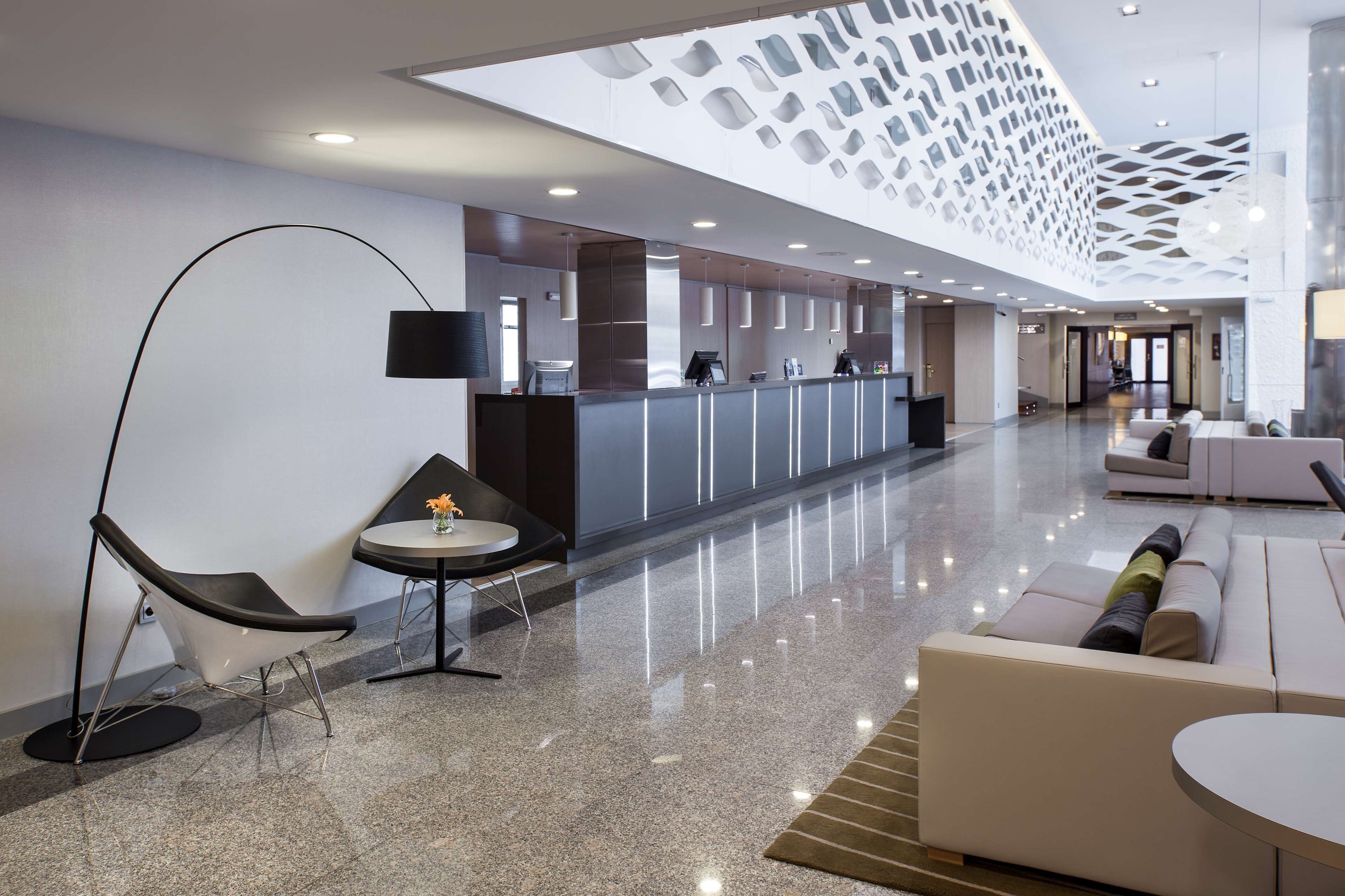Eine moderne Lobby mit einer Rezeption, einer Lounge und einem außergewöhnlichen Deckenstil.