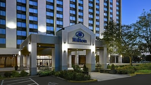 Ein Hilton Hotel mit moderner Fassade, großen Fenstern und einem gut beleuchteten Eingang.