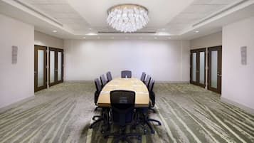 A conference room with a long table, chairs, and a chandelier.