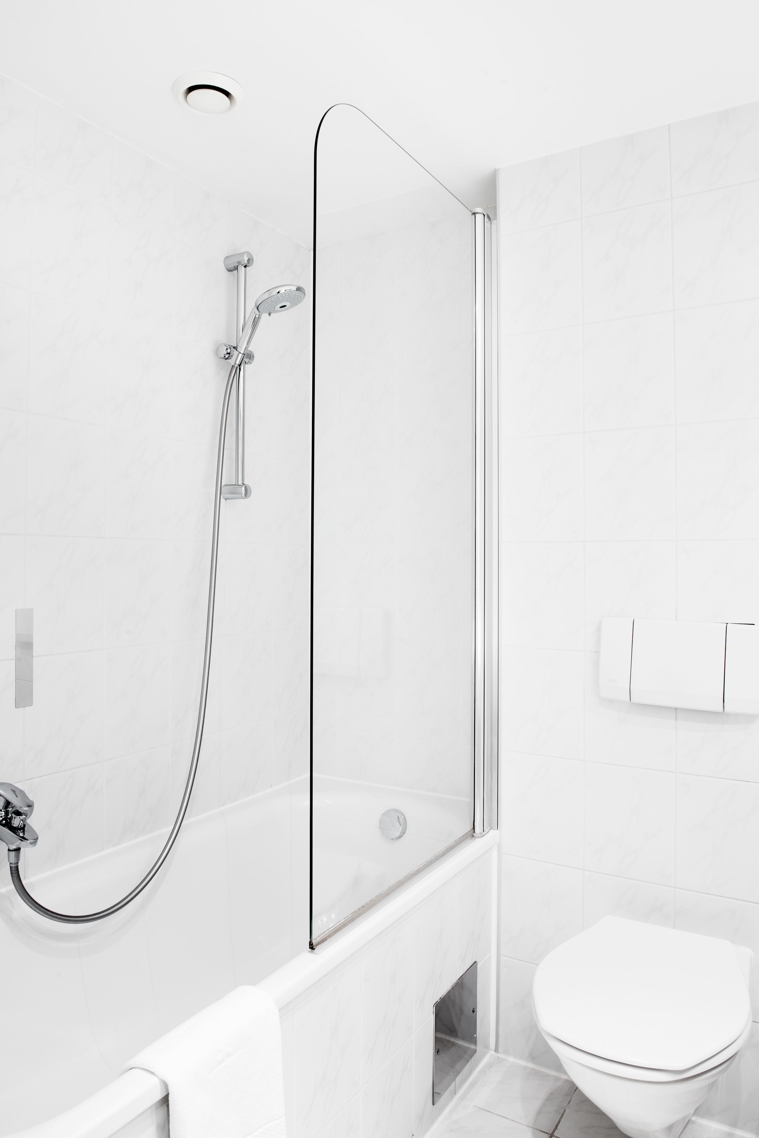 A modern bathroom with a glass-enclosed shower, a white toilet, and a towel rack.