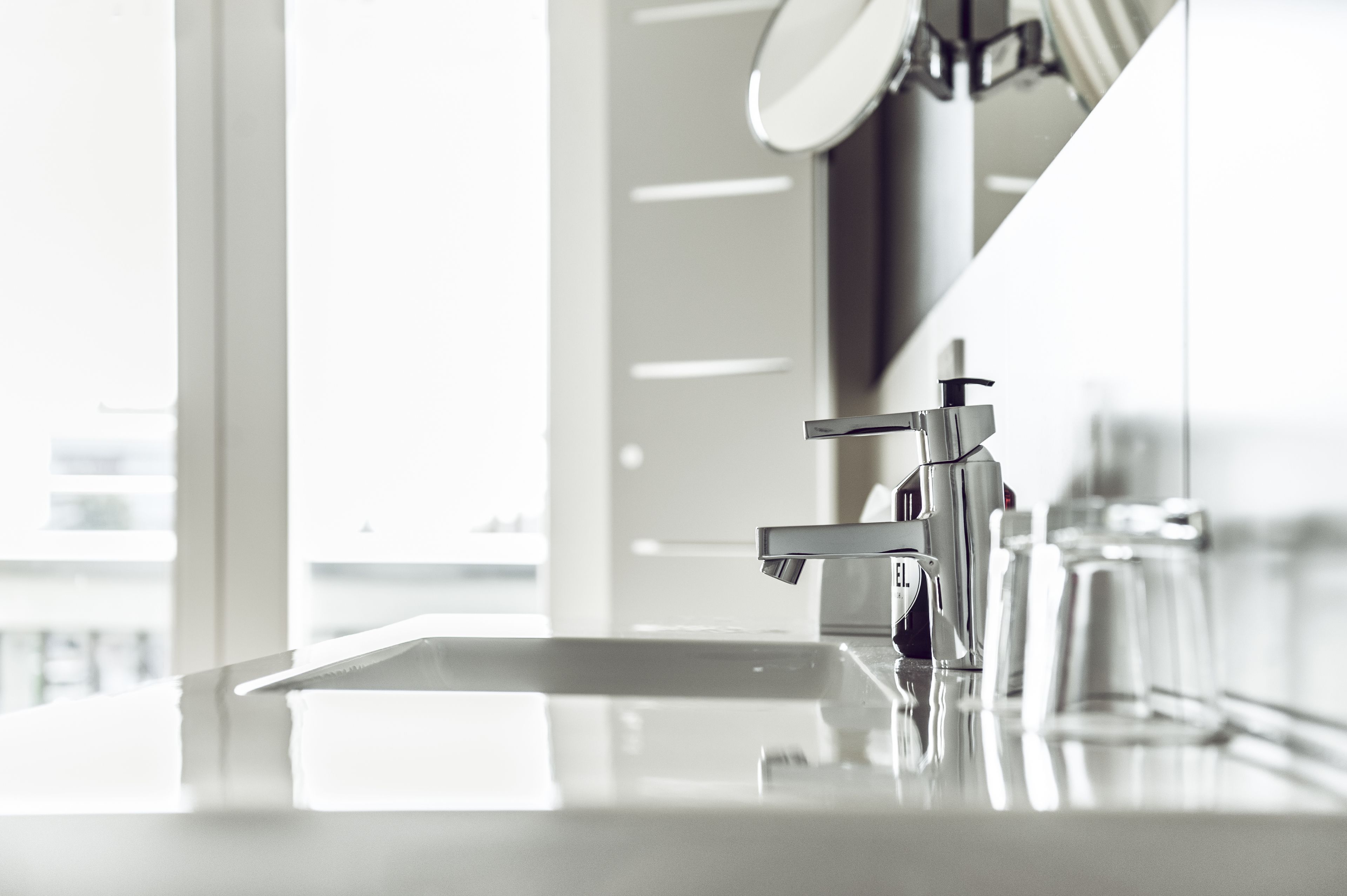 Une salle de bain moderne avec un lavabo élégant et brillant, et un robinet chromé.