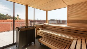 Un interior moderno con ventanas amplias, bancos de madera y una mesa de fútbol.