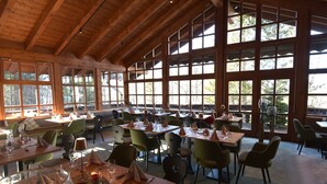 A spacious dining area with wooden beams and large windows, tables set with wine glasses and napkins. - Dorint Sporthotel Garmisch-Partenkirchen (Garmisch-Partenkirchen)