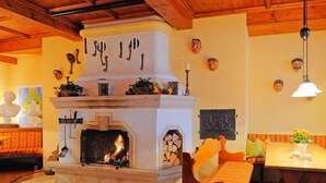A cozy room with a fireplace, wooden furniture, and decorative wall art. - Dorint Sporthotel Garmisch-Partenkirchen (Garmisch-Partenkirchen)